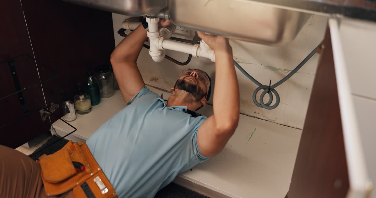 Accounting for plumbers — plumber repairing a kitchen sink